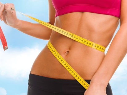sport, fitness and diet concept - close up of trained belly with